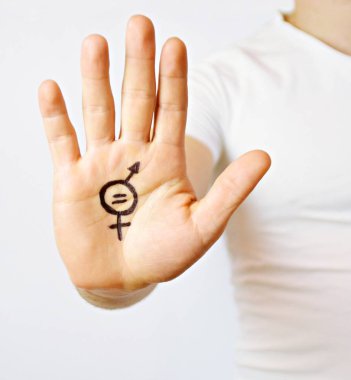 Onun orta yirmili bir adam elinde cinsiyet eşitliği bir işareti boyalı ve kamera gösterir-erkek ve kadınlar arasında eşitlik talep için bir kavram 