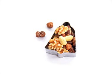 Bir yıldız şeklinde bir çerez kesici beyaz bir arka planda yatıyor ve metin veya nesneler için yer ile Noel şekilleri yumurta kabuğu zengin fındık ile farklı fındık ve kuru üzüm-kavramı ile doldurulur