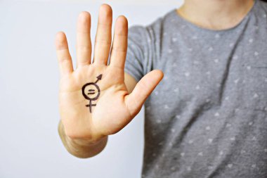 Onun orta yirmili bir adam elinde cinsiyet eşitliği bir işareti boyalı ve kamera gösterir-erkek ve kadınlar arasında eşitlik talep için bir kavram 