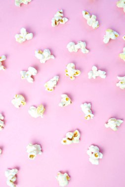 Patlamış mısır, yüzeyde birbirlerinden belirli bir mesafeden yatan patlamış mısır oluşan bir arka plan ile renkli bir yüzey-konsept üzerinde eşit olarak dağıtılır yatıyor 