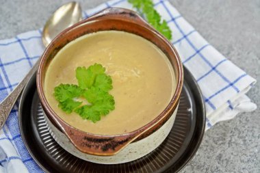 Taze yapılmış ev yapımı karnabahar çorbası maydanoz ve tost beyaz ekmek ile ot tereyağı yayılmış bir mutfak yüzeyi-sağlıklı ve vejetaryen öğle yemeği ile karnabahar ve krem