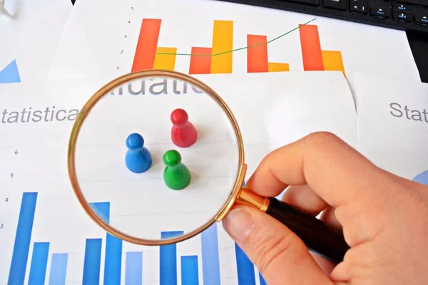 Genç Bir Adam Istatistik Rakamları Bakarak Elinde Bir Büyüteç Tutuyor — Stok fotoğraf