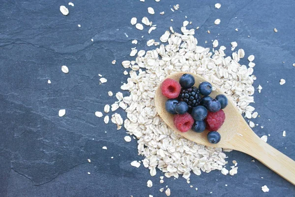 Çilek ve yulaf ezmesi ile sağlıklı bir kahvaltı için bir ahşap kaşık kavramı 