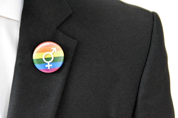 20'li yaşlarının ortasında bir adam takım ceketinde transseksüel sembolü olan bir düğme takıyor - Çalışma Hayatında Kabul ve Hoşgörü Kavramı