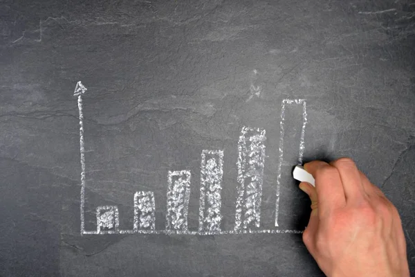 Ekonomik bağlamda istatistik ve değerlendirmeler için tebeşir konsepti ile çizilmiş siyah mermer yüzeyde bir ayaklanma şeması 