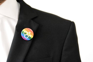 20'li yaşlarının ortasında bir adam takım ceketinde transseksüel sembolü olan bir düğme takıyor - Çalışma Hayatında Kabul ve Hoşgörü Kavramı