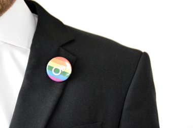 20'li yaşlarının ortasında bir adam takım ceketinde transseksüel sembolü olan bir düğme takıyor - Çalışma Hayatında Kabul ve Hoşgörü Kavramı