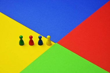 Farklı renkli küçük erkekler oyun figürleri, renkler ve bir takımın çeşitliliği temsil etmek için bu bir toplantı ile aynı renkli yüzey kavramı üzerinde stand 