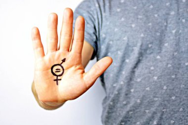Onun orta yirmili bir adam elinde cinsiyet eşitliği bir işareti boyalı ve kamera gösterir-erkek ve kadınlar arasında eşitlik talep için bir kavram 