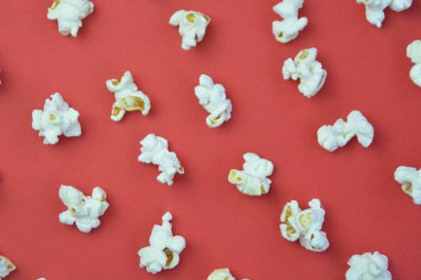 Patlamış mısır, yüzeyde birbirlerinden belirli bir mesafeden yatan patlamış mısır oluşan bir arka plan ile renkli bir yüzey-konsept üzerinde eşit olarak dağıtılır yatıyor 