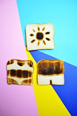 Üç tost renkli bir arka plan üzerinde yalan-bu tüm yüzey üzerinde kızartılmış değil ama Trunks ve bikini konturları ve güneş yanık kavramı bu dondurma ile sunulan gösterir 