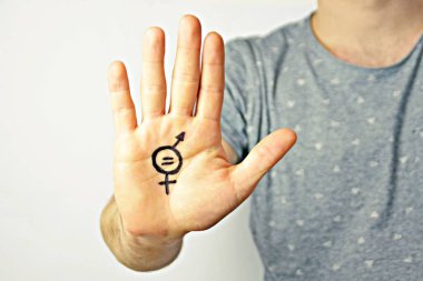 Onun orta yirmili bir adam elinde cinsiyet eşitliği bir işareti boyalı ve kamera gösterir-erkek ve kadınlar arasında eşitlik talep için bir kavram 