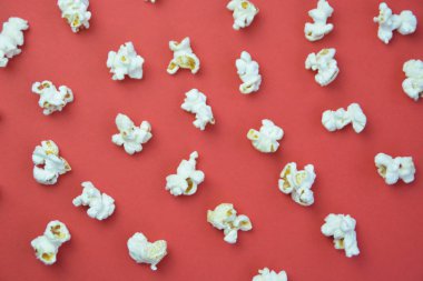 Patlamış mısır, yüzeyde birbirlerinden belirli bir mesafeden yatan patlamış mısır oluşan bir arka plan ile renkli bir yüzey-konsept üzerinde eşit olarak dağıtılır yatıyor 