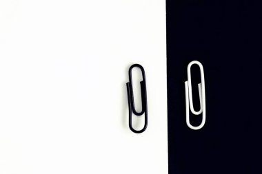 Beyaz kırpılmış bir ataç siyah bir yüzey üzerinde oturur ve başka bir siyah ataç beyaz bir yüzey üzerinde oturur-ataç ile siyah ve beyaz kavramı-Stark kontrastlar ve arka plan olarak farklar