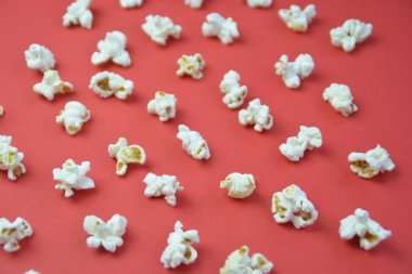 Patlamış mısır, yüzeyde birbirlerinden belirli bir mesafeden yatan patlamış mısır oluşan bir arka plan ile renkli bir yüzey-konsept üzerinde eşit olarak dağıtılır yatıyor 