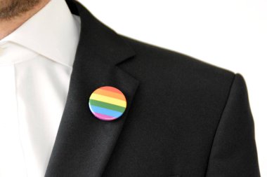 20'li yaşlarının ortasında bir adam takım ceketinde transseksüel sembolü olan bir düğme takıyor - Çalışma Hayatında Kabul ve Hoşgörü Kavramı