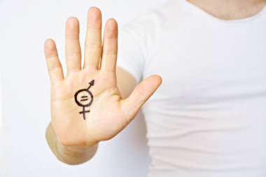 Onun orta yirmili bir adam elinde cinsiyet eşitliği bir işareti boyalı ve kamera gösterir-erkek ve kadınlar arasında eşitlik talep için bir kavram 