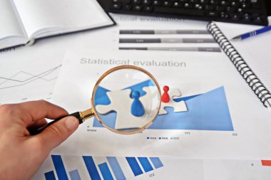 Genç bir adam elinde bulmacanın bir parçası tutar ve bunun arkasında istatistik her türlü-bir yakın çekim bulmaca parçaları ve strateji Tasarım istatistikleri ile el konsepti