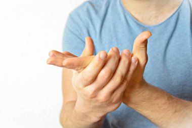 Genç bir adam avuçlarını bir araya getirir - farklı ülkelerde farklı anlamlara sahip bir jest, adamın ellerine odaklanarak 