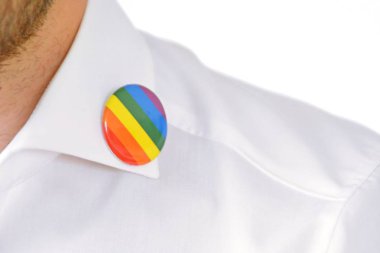 20'li yaşlarının ortasında bir adam takım ceketinde transseksüel sembolü olan bir düğme takıyor - Çalışma Hayatında Kabul ve Hoşgörü Kavramı