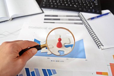 Genç bir adam elinde bulmacanın bir parçası tutar ve bunun arkasında istatistik her türlü-bir yakın çekim bulmaca parçaları ve strateji Tasarım istatistikleri ile el konsepti