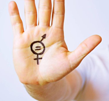 Onun orta yirmili bir adam elinde cinsiyet eşitliği bir işareti boyalı ve kamera gösterir-erkek ve kadınlar arasında eşitlik talep için bir kavram 