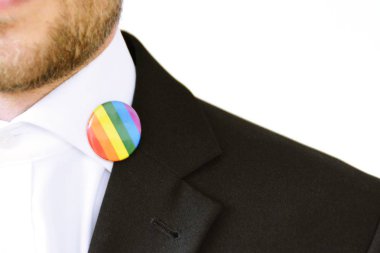 20'li yaşlarının ortasında bir adam takım ceketinde transseksüel sembolü olan bir düğme takıyor - Çalışma Hayatında Kabul ve Hoşgörü Kavramı