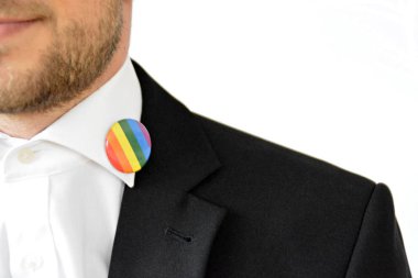 20'li yaşlarının ortasında bir adam takım ceketinde transseksüel sembolü olan bir düğme takıyor - Çalışma Hayatında Kabul ve Hoşgörü Kavramı