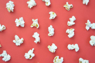 Patlamış mısır, yüzeyde birbirlerinden belirli bir mesafeden yatan patlamış mısır oluşan bir arka plan ile renkli bir yüzey-konsept üzerinde eşit olarak dağıtılır yatıyor 