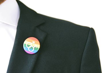 20'li yaşlarının ortasında bir adam takım ceketinde transseksüel sembolü olan bir düğme takıyor - Çalışma Hayatında Kabul ve Hoşgörü Kavramı