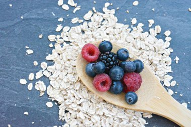 Çilek ve yulaf ezmesi ile sağlıklı bir kahvaltı için bir ahşap kaşık kavramı 