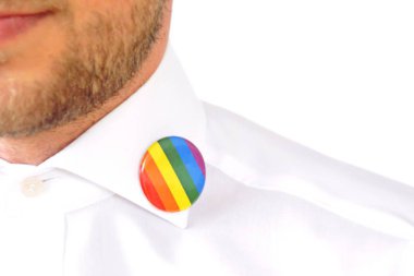 20'li yaşlarının ortasında bir adam takım ceketinde transseksüel sembolü olan bir düğme takıyor - Çalışma Hayatında Kabul ve Hoşgörü Kavramı