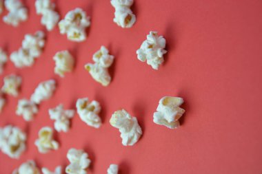 Patlamış mısır, yüzeyde birbirlerinden belirli bir mesafeden yatan patlamış mısır oluşan bir arka plan ile renkli bir yüzey-konsept üzerinde eşit olarak dağıtılır yatıyor 