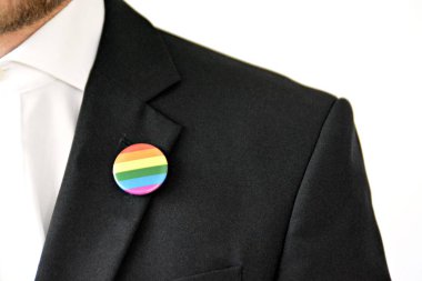 20'li yaşlarının ortasında bir adam takım ceketinde transseksüel sembolü olan bir düğme takıyor - Çalışma Hayatında Kabul ve Hoşgörü Kavramı