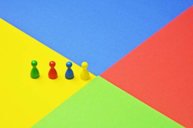 Farklı renkli küçük erkekler oyun figürleri, renkler ve bir takımın çeşitliliği temsil etmek için bu bir toplantı ile aynı renkli yüzey kavramı üzerinde stand -
