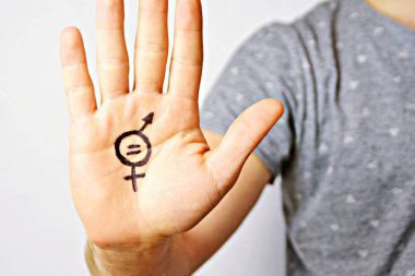 Onun orta yirmili bir adam elinde cinsiyet eşitliği bir işareti boyalı ve kamera gösterir-erkek ve kadınlar arasında eşitlik talep için bir kavram 