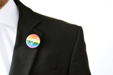20'li yaşlarının ortasında bir adam takım ceketinde transseksüel sembolü olan bir düğme takıyor - Çalışma Hayatında Kabul ve Hoşgörü Kavramı