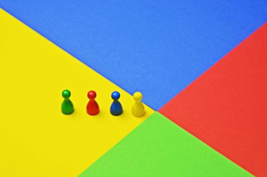 Farklı renkli küçük erkekler oyun figürleri, renkler ve bir takımın çeşitliliği temsil etmek için bu bir toplantı ile aynı renkli yüzey kavramı üzerinde stand -