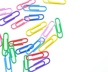 Çeşitli renkli kağıt klipler beyaz bir yüzey üzerinde yatıyor-bir arka plan beyaz bir taban ve renkli ataç oluşan