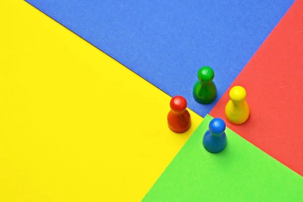 異なる色の小さな男性が同じ色の表面に立っている ゲームのフィギュア 色とチームの多様性を表すために これらの会議との概念 — ストック写真