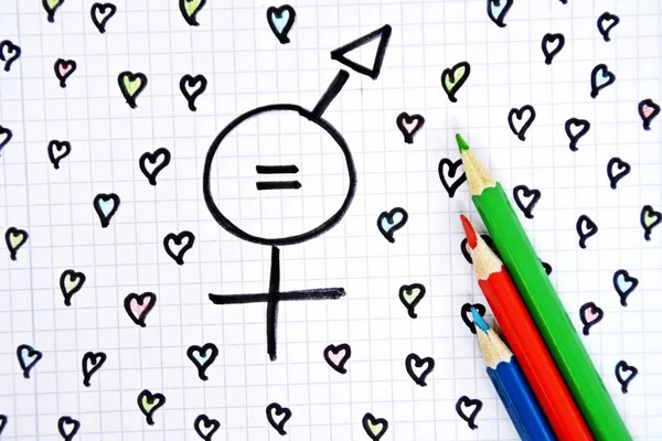 A sign for the equality of man and woman consisting of the respective gender signs and a match with painted hearts and colored pencils on a drawn sheet -equality man and woman symbolically represented