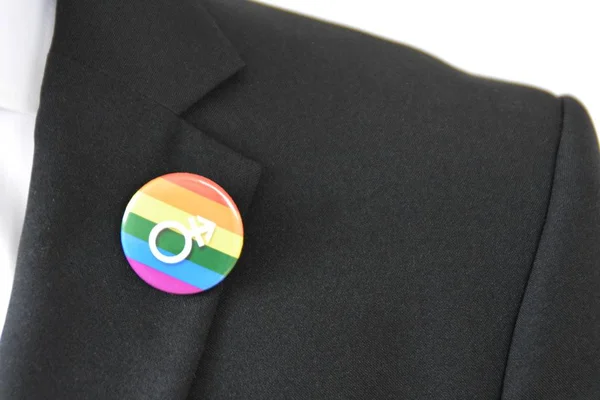 20'li yaşlarının ortasında bir adam takım ceketinde transseksüel sembolü olan bir düğme takıyor - Çalışma Hayatında Kabul ve Hoşgörü Kavramı