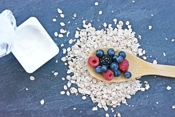 Çilek ve yulaf ezmesi ile sağlıklı bir kahvaltı için bir ahşap kaşık kavramı 