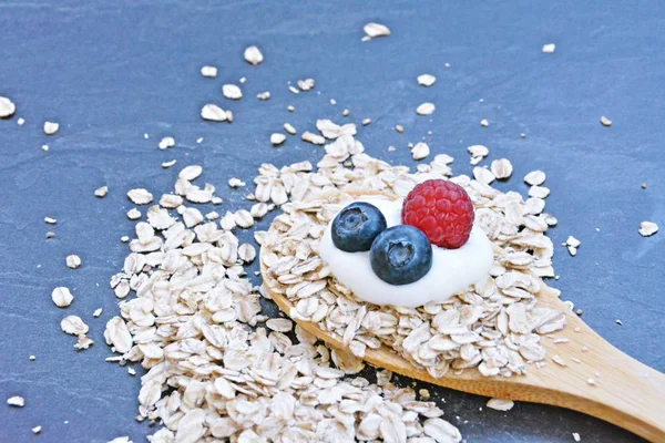 Çilek ve yulaf ezmesi ile sağlıklı bir kahvaltı için bir ahşap kaşık kavramı 