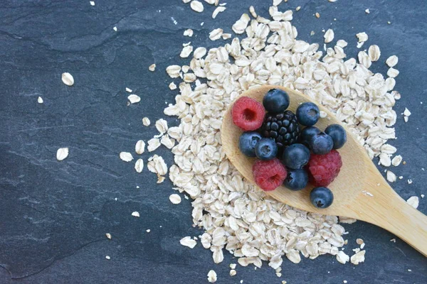 Çilek ve yulaf ezmesi ile sağlıklı bir kahvaltı için bir ahşap kaşık kavramı 
