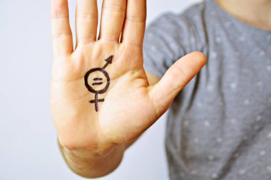 Onun orta yirmili bir adam elinde cinsiyet eşitliği bir işareti boyalı ve kamera gösterir-erkek ve kadınlar arasında eşitlik talep için bir kavram
