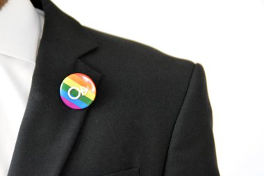 20'li yaşlarının ortasında bir adam takım ceketinde transseksüel sembolü olan bir düğme takıyor - Çalışma Hayatında Kabul ve Hoşgörü Kavramı