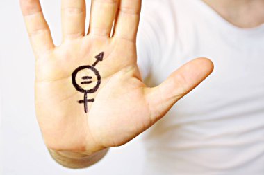 Onun orta yirmili bir adam elinde cinsiyet eşitliği bir işareti boyalı ve kamera gösterir-erkek ve kadınlar arasında eşitlik talep için bir kavram