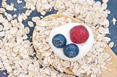 Çilek ve yulaf ezmesi ile sağlıklı bir kahvaltı için bir ahşap kaşık kavramı 