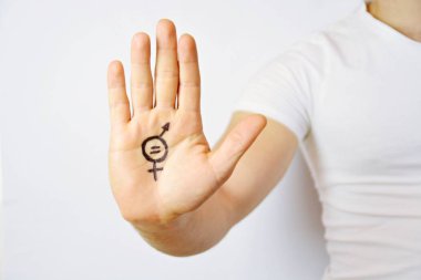 Onun orta yirmili bir adam elinde cinsiyet eşitliği bir işareti boyalı ve kamera gösterir-erkek ve kadınlar arasında eşitlik talep için bir kavram